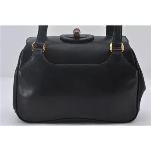 Mod Gucci, black leather shoulder bag with two longer straps, two exterior pockets, a hinged opening, and a gold and bamboo accent clasp
